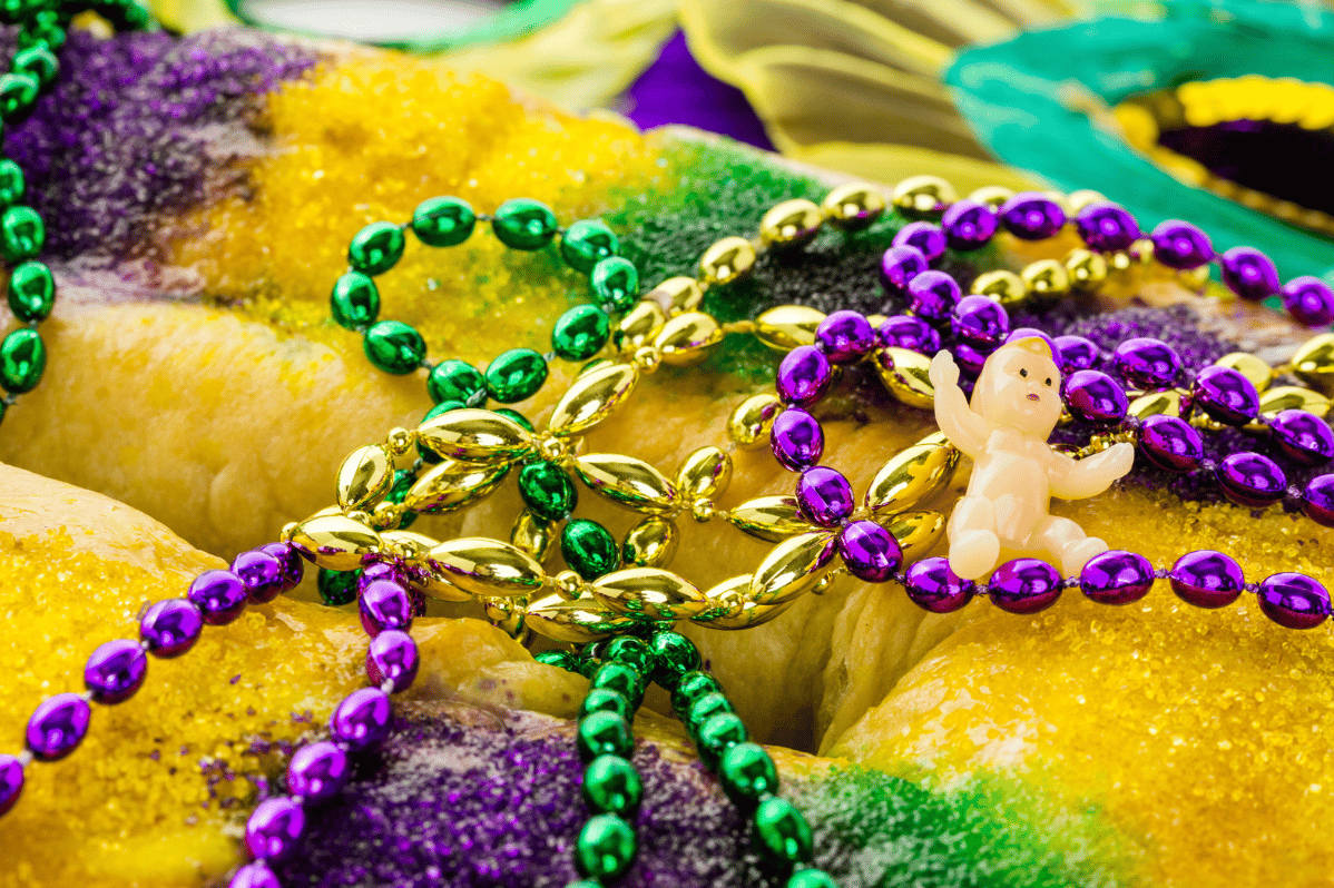 Fat Tuesday Mardi Gras king cake with baby and beads